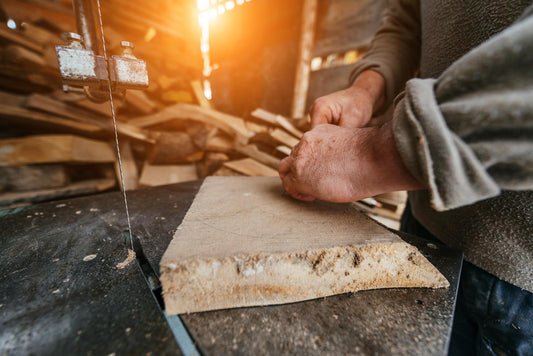 Carpenter Cutting Wood with a Bandsaw in a Rustic Workshop