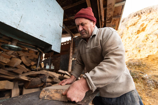 Carpenter Cutting Wood with a Bandsaw in a Rustic Workshop