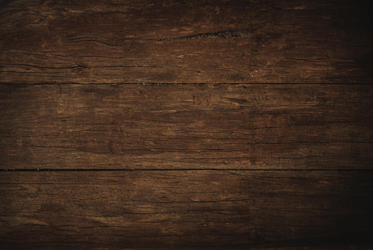 Close-up of a dark rustic wooden plank surface with natural textures and wood grain patterns.